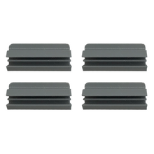 Four gray, grooved plastic caps are arranged in a two-by-two grid on a white background.