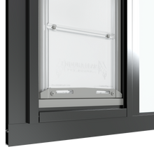 The bottom section of a black Thermo Sash 3e cat door windows is shown closed within a window, highlighting its secure fit in a sash window and the rubber seal for sash windows.