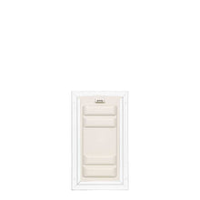 An off-white pet door is framed in white.