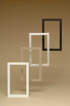 Four empty rectangular frames, ranging from white to black, arranged in a diagonal line on a neutral background.