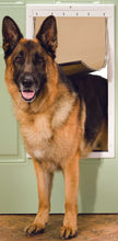 A German Shepherd dog is coming through a dog door.