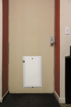 A door with a small, white access panel near the bottom.