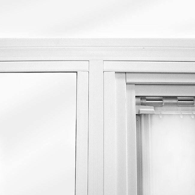 Close-up of a white window frame with a semi-transparent curtain.