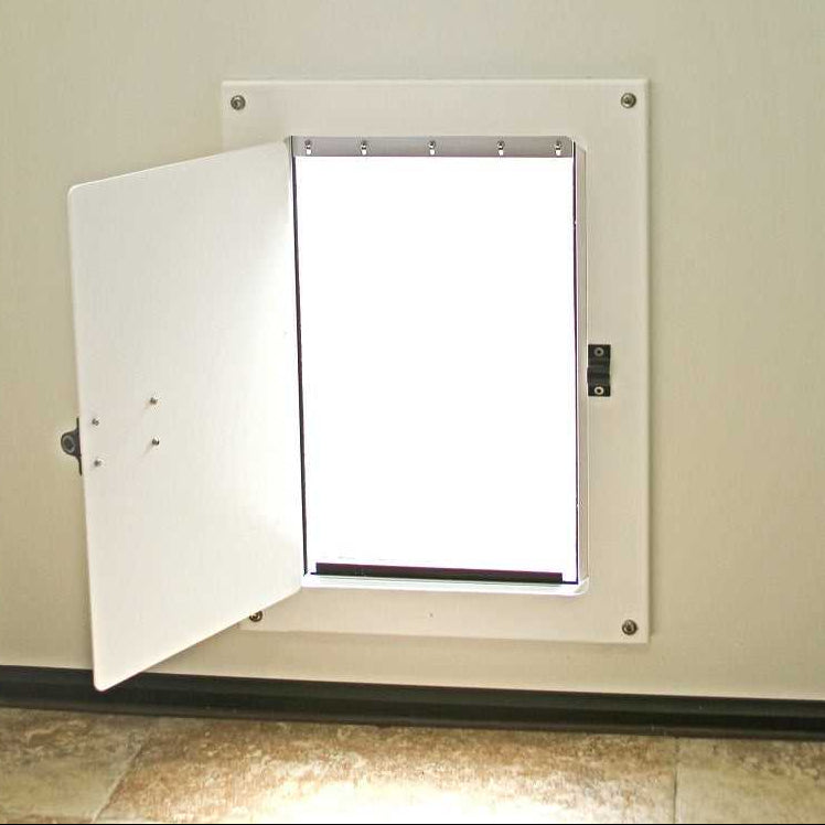 A pet door with a white frame and open flap is installed in a wall.