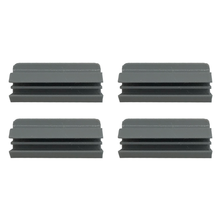 Four gray, grooved plastic caps are arranged in a two-by-two grid on a white background.