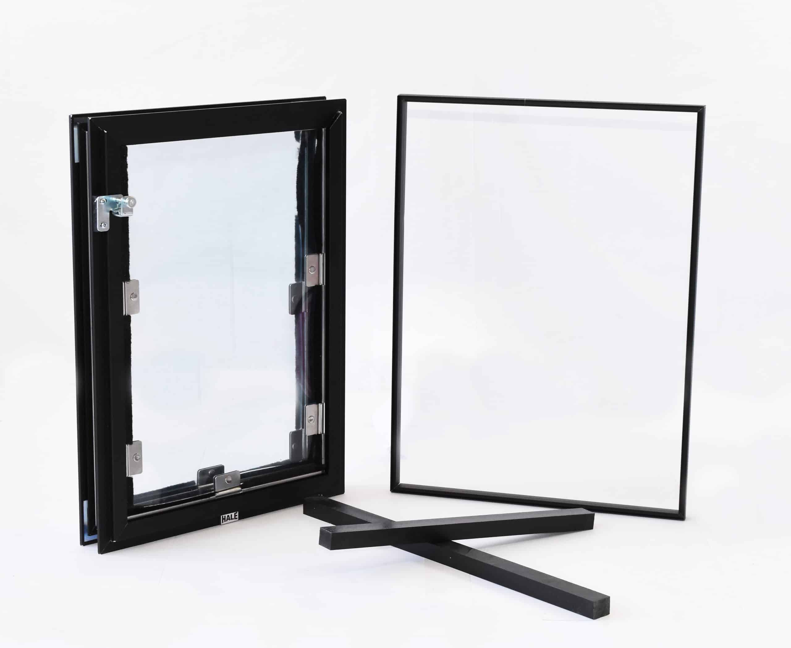Black-framed glass window insert and separate frame with two black support pieces.