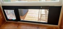 A pet door and window insert with a sliding door is installed in a sliding glass door frame.