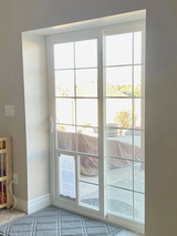 White sliding glass door with a pet door insert leading to a patio.