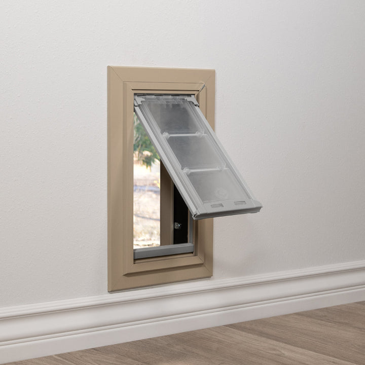 Pet door installed in a wall, flap ajar.