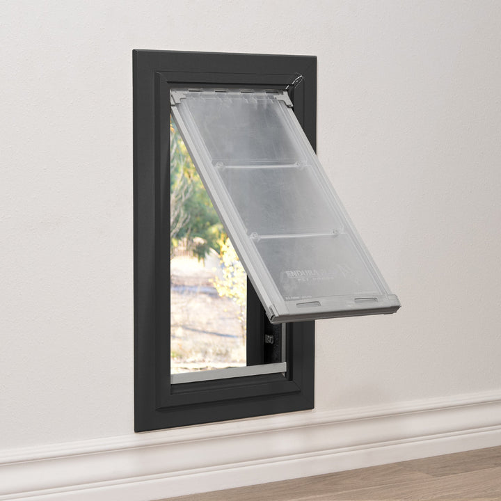 A pet door with a partially open, transparent flap is installed in a wall.