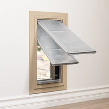 A pet door with two clear flaps is installed in a wall.