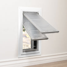 A pet door with transparent flaps is installed in a wall.