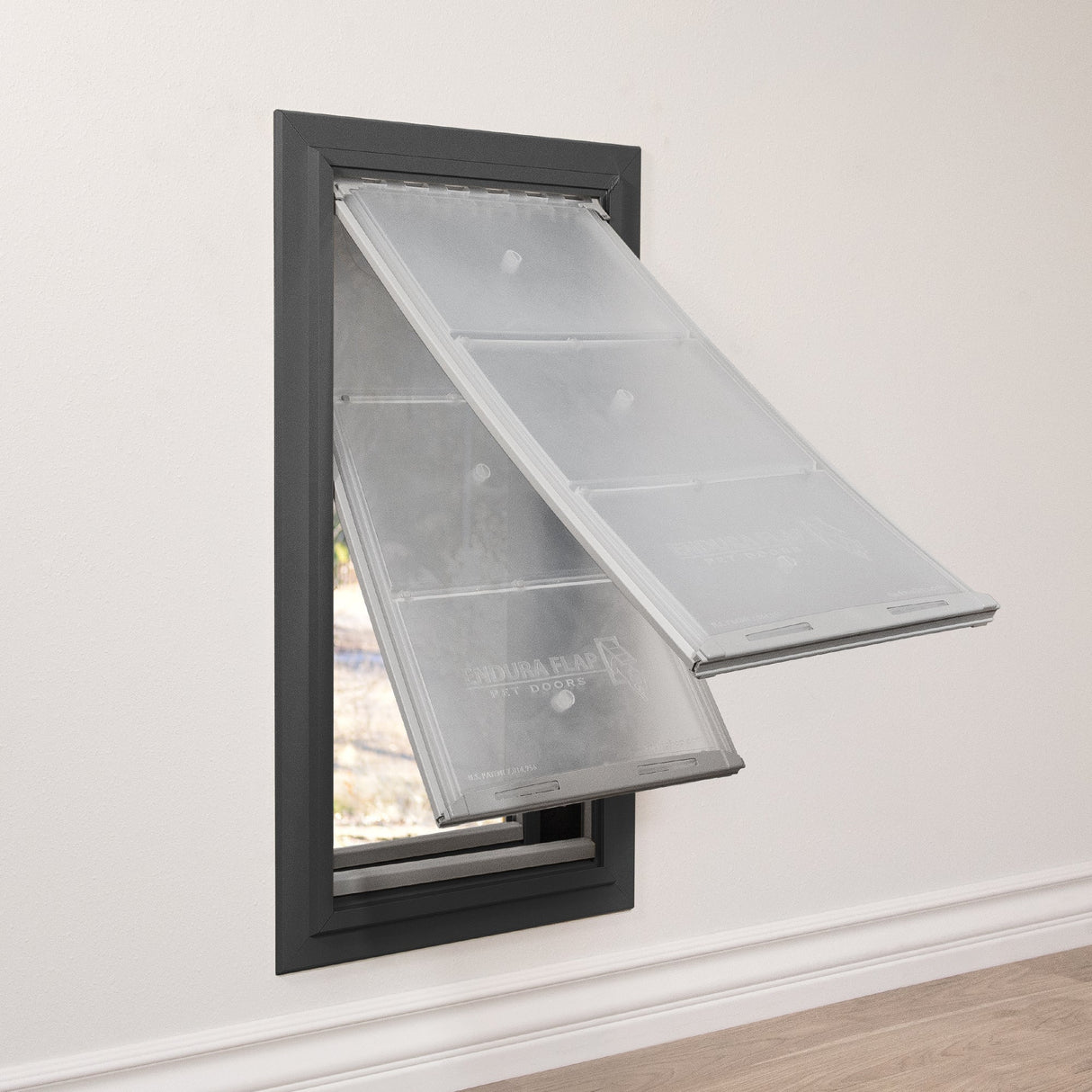 A pet door with two translucent flaps is installed in a wall.