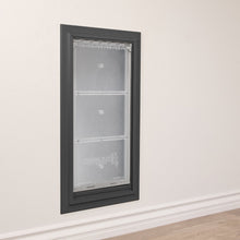 A dark-framed Endura Flap pet door is installed in a white wall.
