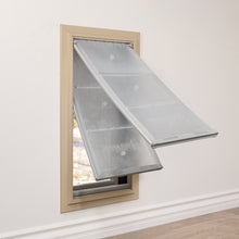 A tan-framed pet door with two transparent flaps is installed in a wall.