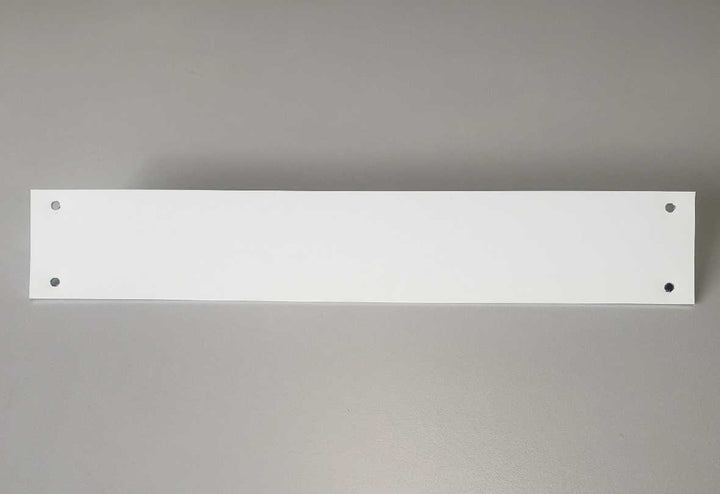 A white rectangular board with four holes is centered on a gray background.