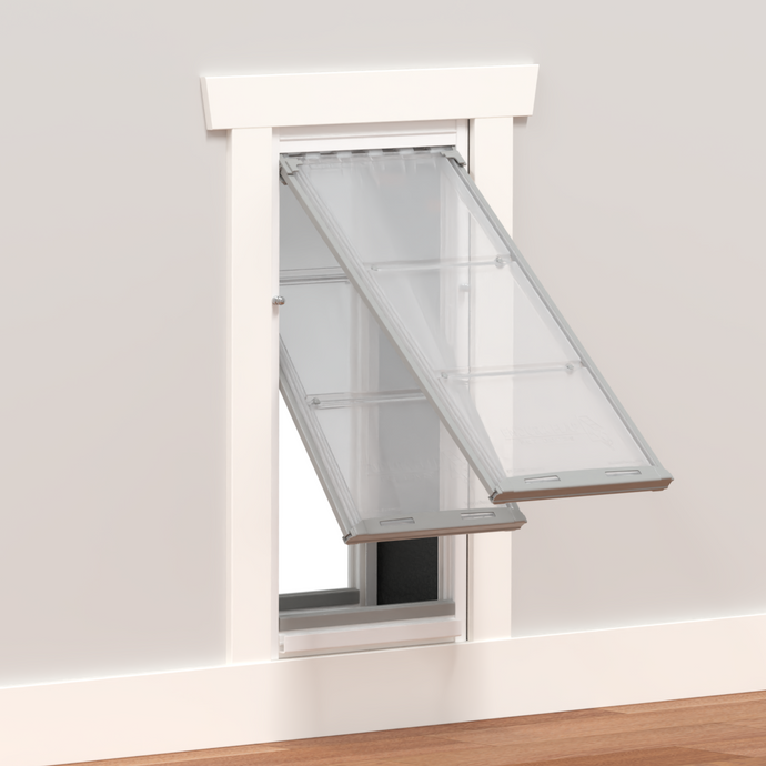 A pet door with clear flaps installed in a wall.