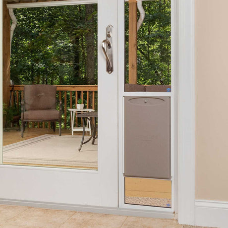 A patio door with a dog door installed leads to an outdoor deck.