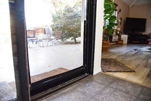 View through a screen door to an outdoor patio.