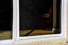 A close-up of a window with a white frame and a black screen.