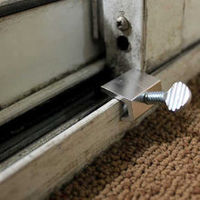 A metal sliding door lock is installed on a white door frame.
