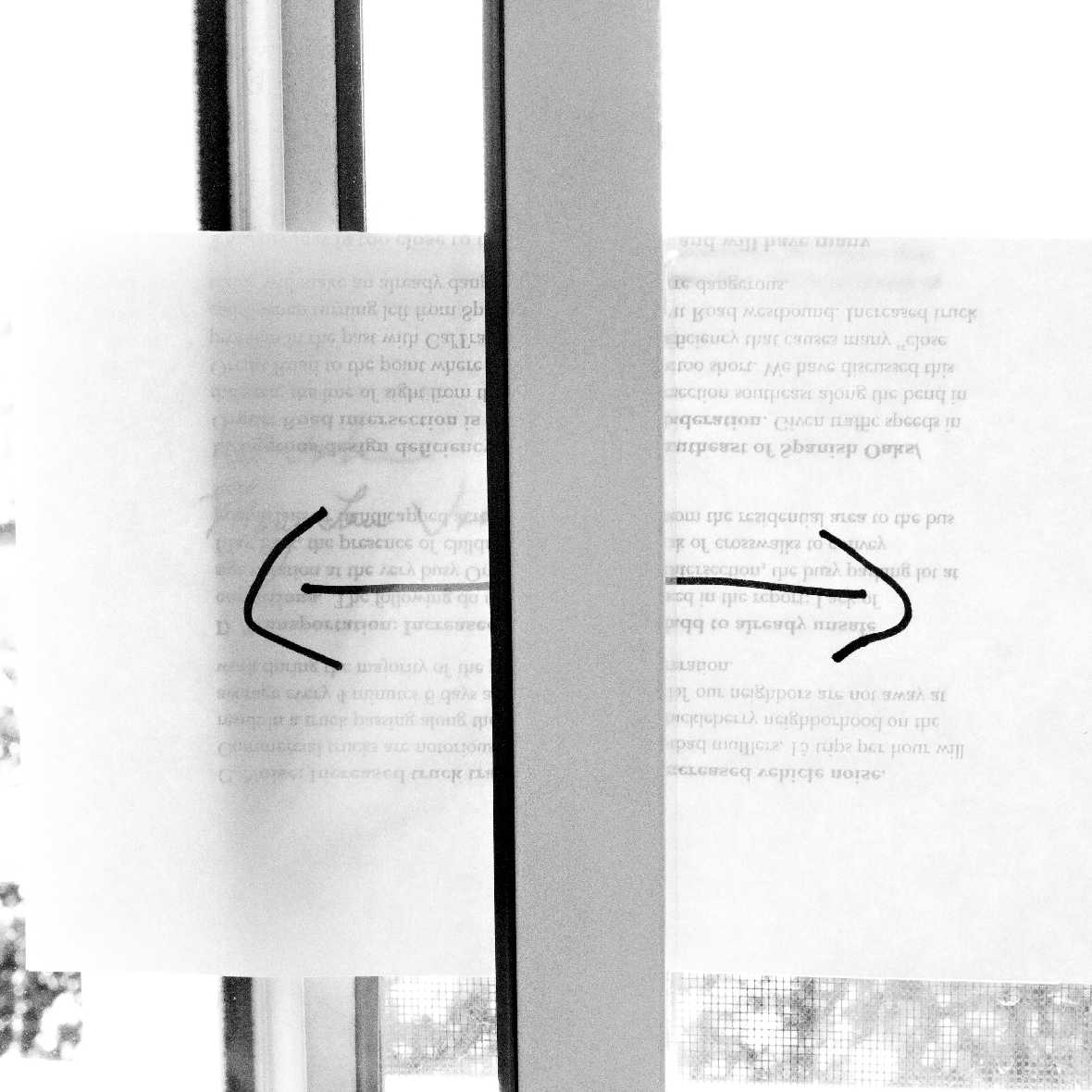Sheets of paper with overlapping text and curving arrows are held in place by an opaque object.