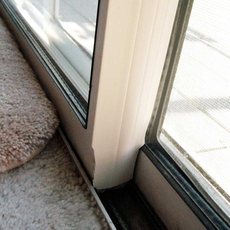 Close-up of a sliding glass door frame and carpet.