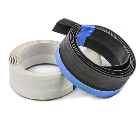 Two rolls of flexible plastic trim, one white and one black, bound with blue tape.