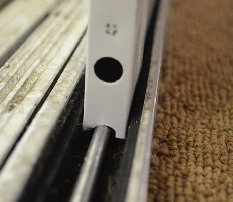 Close-up of a sliding door track and roller.