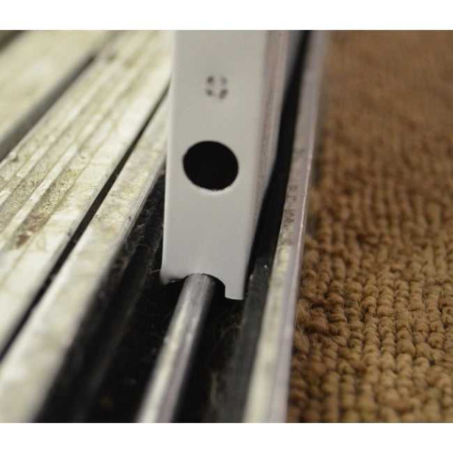 Close-up of a sliding door track with a white guide.
