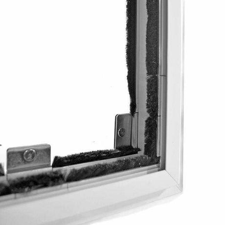 Close-up of a white-framed window with weather stripping and metal hardware.