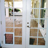 White French doors with a dog door in the lower-left panel open to a tiled patio_Color_Frame