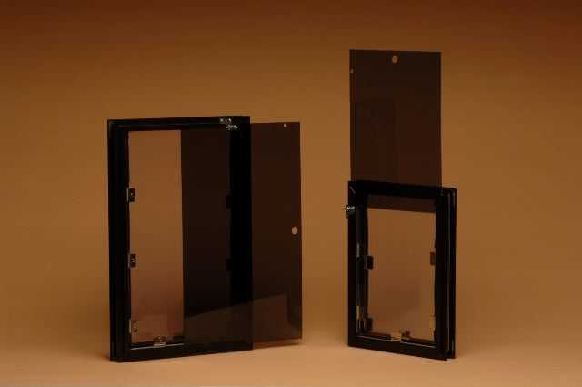 Two dark window frames with attached tinted glass panels on a brown background.