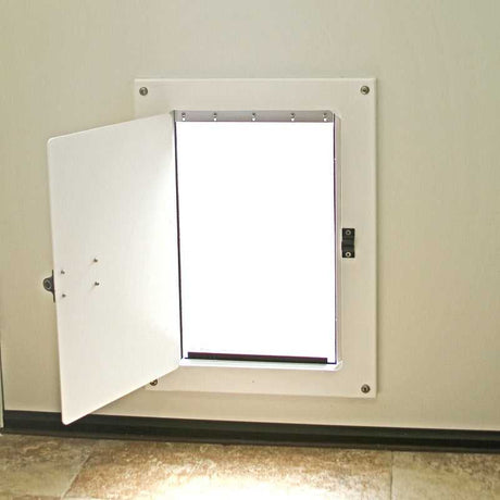 A pet door with a white frame and open flap is installed in a wall.